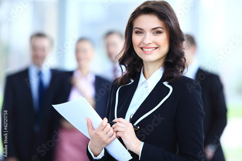 Photo: Face of beautiful woman on the background of business people Face of beautiful woman on the background of business people