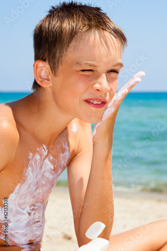 Photo: Boy applying sunscreen Boy applying sunscreen