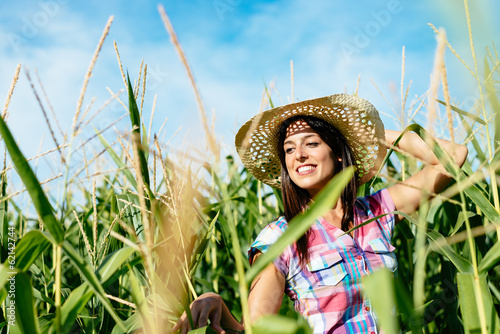 Photo: Beautiful female farmer in corn field Beautiful female farmer in corn field