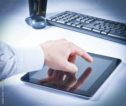 Photo: businessman hand touch tablet pc in the office businessman hand touch tablet pc in the office