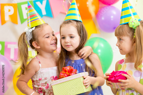 Photo: pretty children giving gifts on birthday party pretty children giving gifts on birthday party
