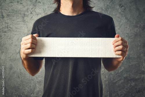 Photo: Man holding white banner Man holding white banner
