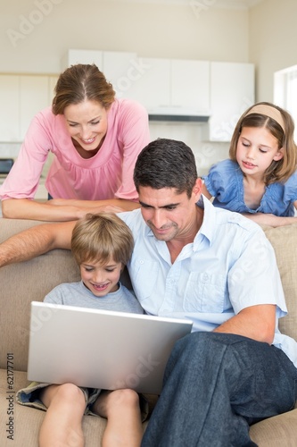 Photo: Family using laptop in living room Family using laptop in living room