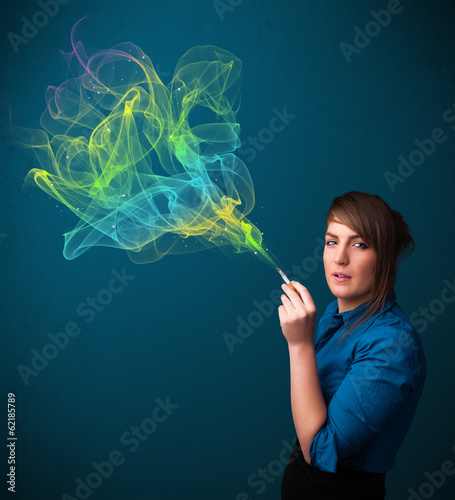 Photo: Pretty lady smoking cigarette with colorful smoke Pretty lady smoking cigarette with colorful smoke