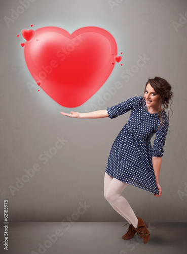 Photo: Young lady holding lovely 3d red heart Young lady holding lovely 3d red heart