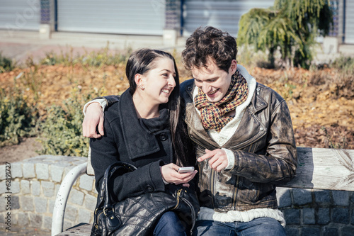 Photo: Young Couple Using Mobile Phone Young Couple Using Mobile Phone
