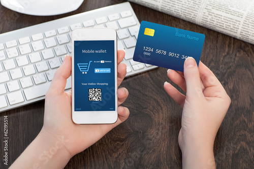 Photo: female hands holding credit card and phone in the office and mak female hands holding credit card and phone in the office and mak