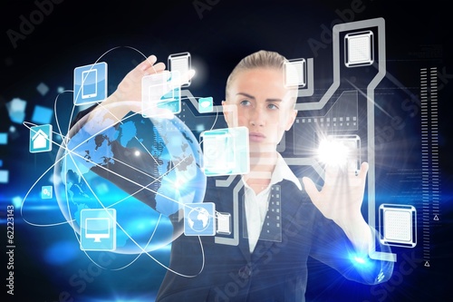 Photo: Blonde businesswoman touching interface Blonde businesswoman touching interface