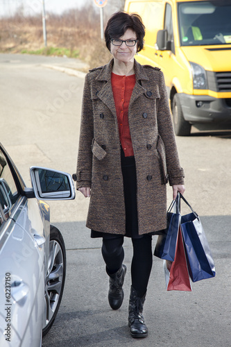 Photo: Woman with shopping bags next car Woman with shopping bags next car