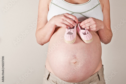 Photo: Pregnant woman holding babies first booties Pregnant woman holding babies first booties