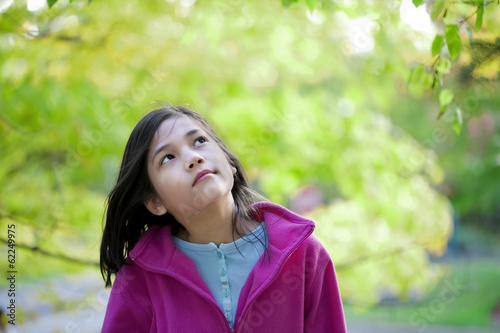 Photo: young girl looking up at autumn leaves young girl looking up at autumn leaves