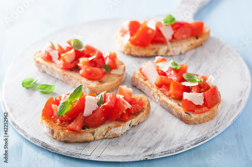 Photo: Italian bruschetta with tomatoes, parmesan, garlic and olive oil Italian bruschetta with tomatoes, parmesan, garlic and olive oil