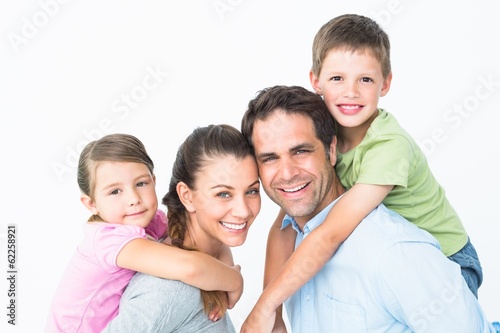 Photo: Cheerful young family looking at camera together Cheerful young family looking at camera together