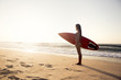 Beautiful surfer girl in the beach with her surfboard at sunset Beautiful surfer girl in the beach with her surfboard at sunset
