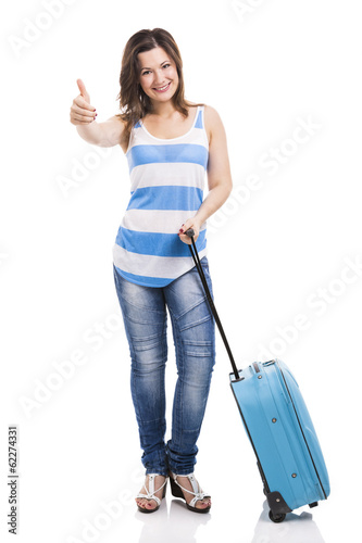 Photo: Beautiful young woman carrying her luggage ready for trave Beautiful young woman carrying her luggage ready for trave