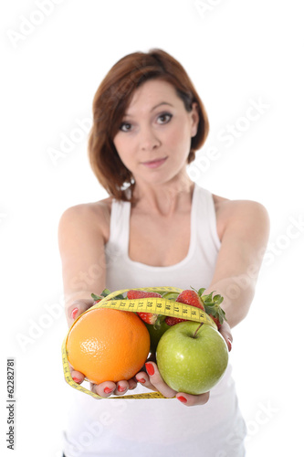 Photo: woman hands with fruit bond with measure tape slave to diet con woman hands with fruit bond with measure tape slave to diet con