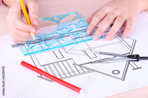 Photo: Architectural project with female hands, close up Architectural project with female hands, close up