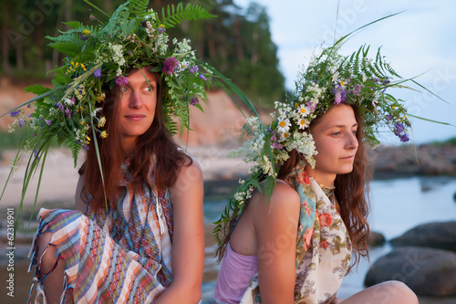 Photo: Two beautiful Girls with summer wreath of grass and flowers on t Two beautiful Girls with summer wreath of grass and flowers on t