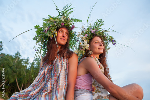 Photo: Two beautiful Girls with summer wreath of grass and flowers on t Two beautiful Girls with summer wreath of grass and flowers on t