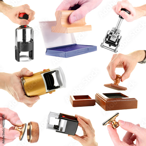Photo: Collage of different stamps in hand isolated on white Collage of different stamps in hand isolated on white