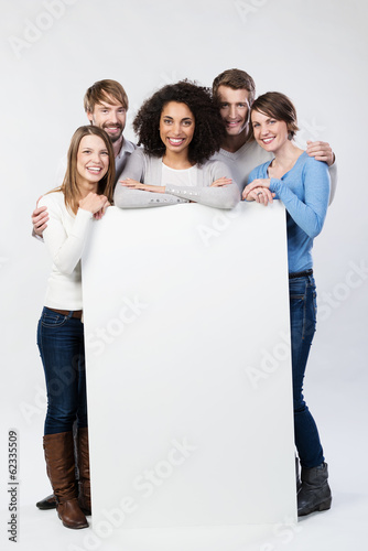 Photo: lachende freunde zeigen weißes schild lachende freunde zeigen weißes schild