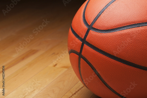 Photo: Basketball shot close up on hardwood gym floor Basketball shot close up on hardwood gym floor