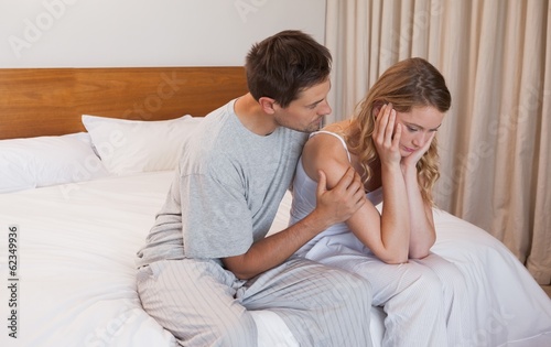 Photo: Man consoling a sad woman in bedroom Man consoling a sad woman in bedroom