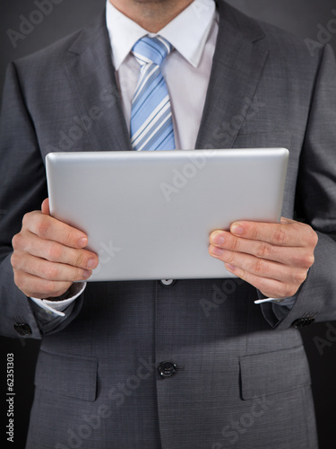 Photo: Businessperson Holding Digital Tablet In Hand Businessperson Holding Digital Tablet In Hand