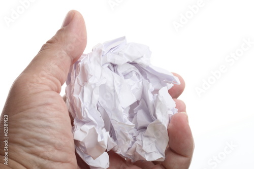 Photo: male hand holding crumpled paper over a white male hand holding crumpled paper over a white
