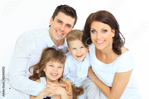 Photo: Beautiful happy family - isolated over a white background Beautiful happy family - isolated over a white background