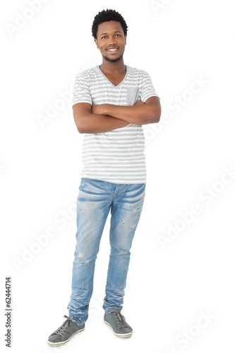 Photo: Full length portrait of a smiling man with arms crossed Full length portrait of a smiling man with arms crossed