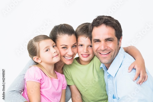 Photo: Cute family smiling at camera together Cute family smiling at camera together