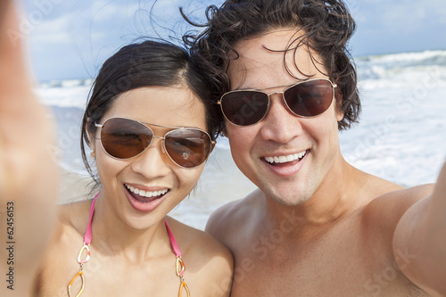 Photo: Asian Couple at Beach Taking Selfie Photograph Asian Couple at Beach Taking Selfie Photograph