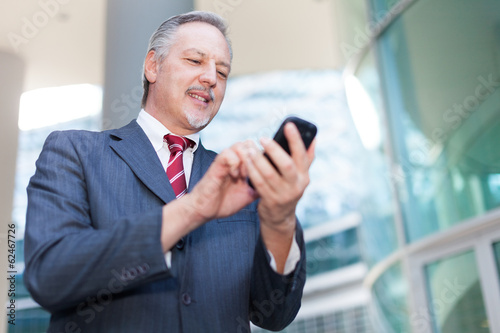 Photo: Businessman using his smartphone Businessman using his smartphone