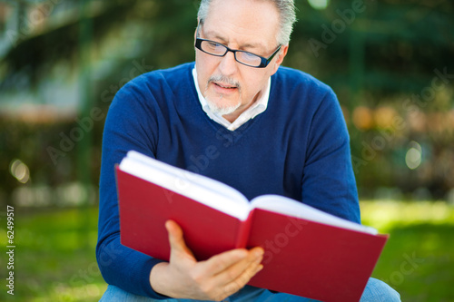 Photo: Mature man reading a book Mature man reading a book