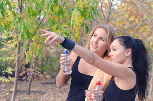 Photo: Two fit young women athletes drinking water Two fit young women athletes drinking water
