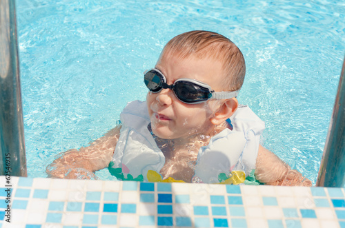 Photo: Laughing little boy climbing out of a pool Laughing little boy climbing out of a pool