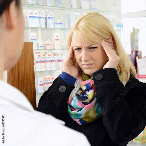 Photo: Frau mit Migräne in Apotheke Frau mit Migräne in Apotheke