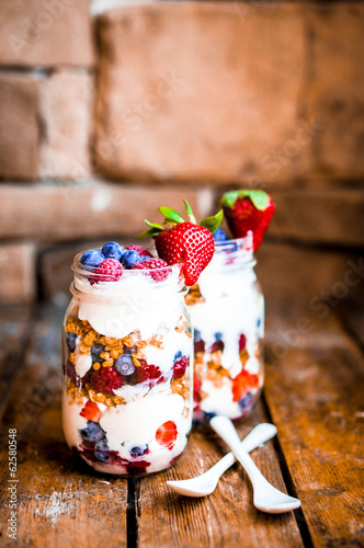 Photo: Granola Parfait with yogurt and berries on rustic background Granola Parfait with yogurt and berries on rustic background