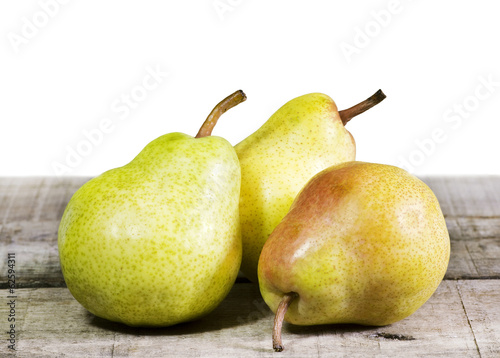 Photo: three pears on wooden table three pears on wooden table