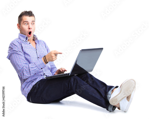 Photo: happy man working on laptop in casuals happy man working on laptop in casuals
