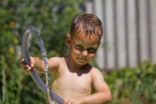 Photo: boy squirting water from a hose boy squirting water from a hose