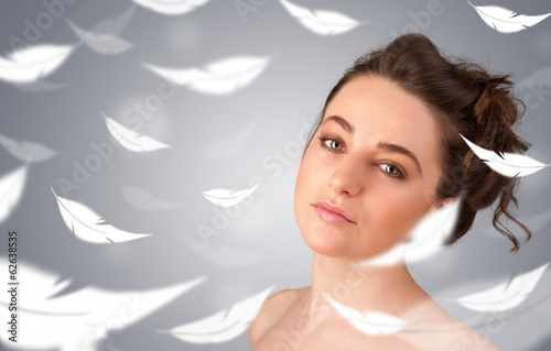 Photo: Beautifull young girl with light feather skin concept Beautifull young girl with light feather skin concept