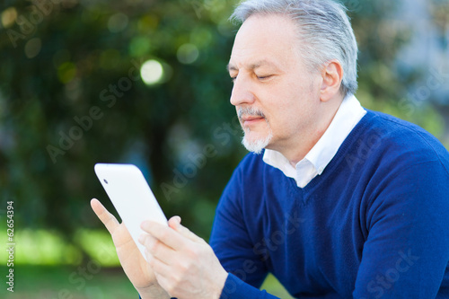 Photo: Mature man using a tablet Mature man using a tablet