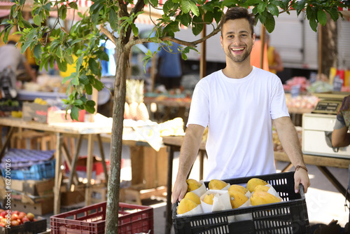 Photo: Small business owner selling organic fruits and vegetables. Small business owner selling organic fruits and vegetables.