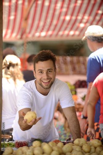 Photo: Small business owner selling organic fruits and vegetables. Small business owner selling organic fruits and vegetables.