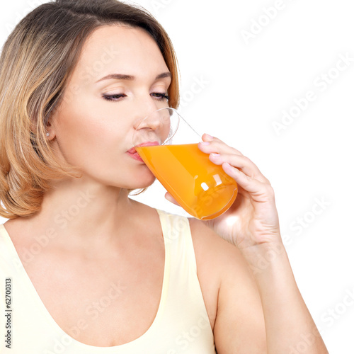 Photo: Profile portrait of a young woman drinks orange juice. Profile portrait of a young woman drinks orange juice.