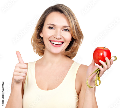 Photo: Portrait of a beautiful young woman with a measuring tape and ap Portrait of a beautiful young woman with a measuring tape and ap