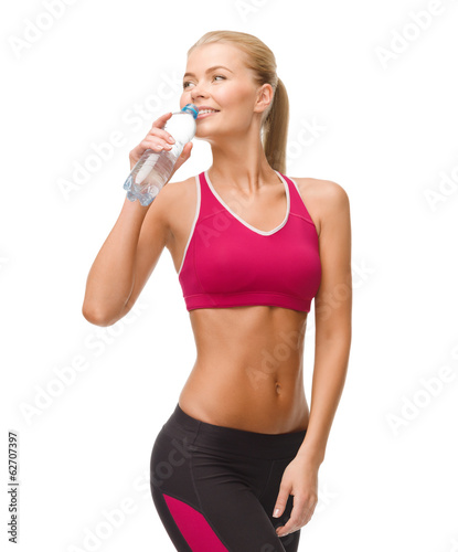 Photo: smiling woman with bottle of water smiling woman with bottle of water