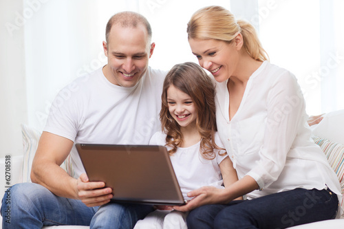 Photo: parents and little girl with laptop at home parents and little girl with laptop at home